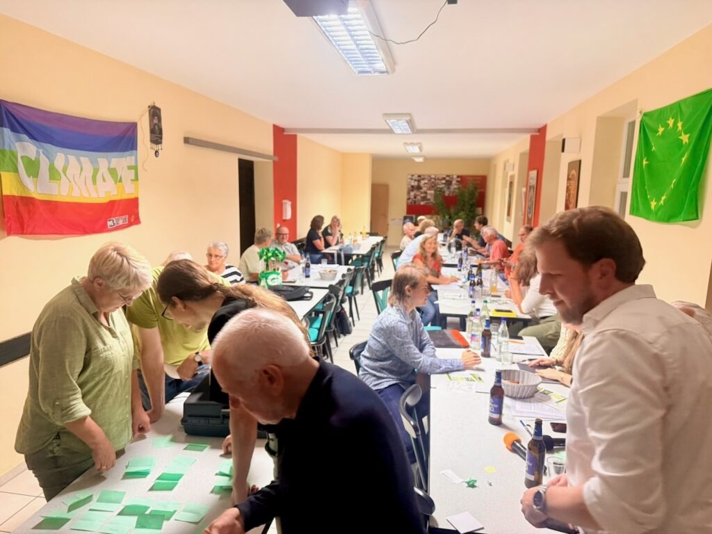 Gute Stimmung bei der Kreismitgliederversammlung von BÜNDNIS 90/DIE GRÜNEN Alzey-Worms am 26.08.2026. Im Vordergrund wird ein Wahlgang ausgezählt.